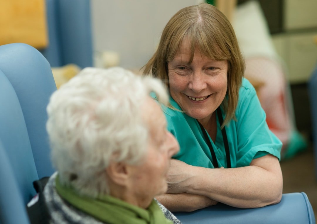 woman-in-scrubs-talking-to-senior-qw3dlnehg9w